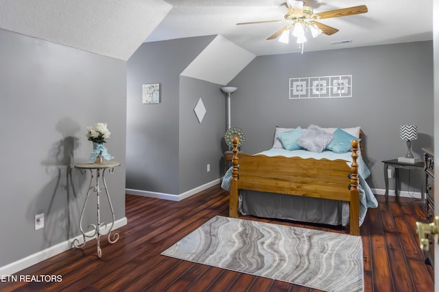 bedroom with a textured ceiling, ceiling fan, dark hardwood / wood-style flooring, and vaulted ceiling