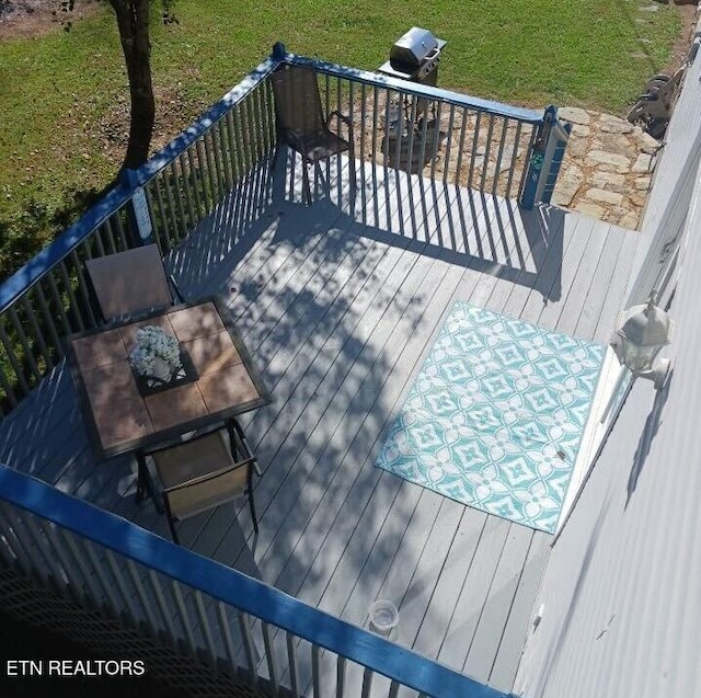 wooden deck featuring a lawn