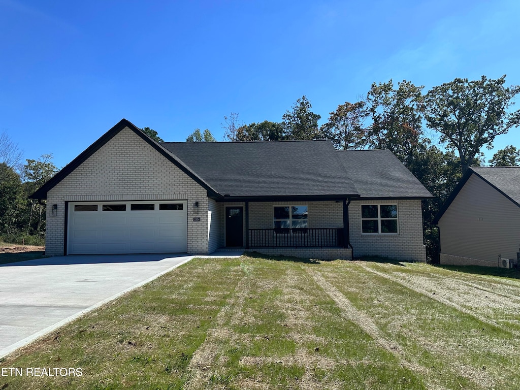 view of front of property featuring a front yard and a garage