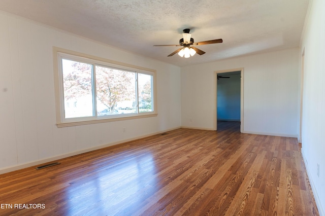 unfurnished room with ceiling fan, dark wood-type flooring, and a textured ceiling