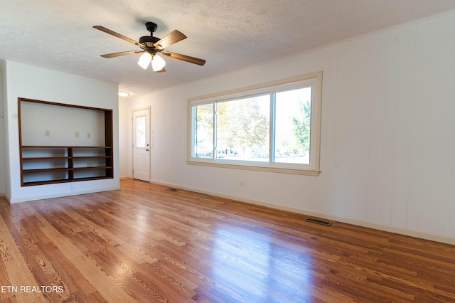 unfurnished room with a textured ceiling, ceiling fan, and hardwood / wood-style floors