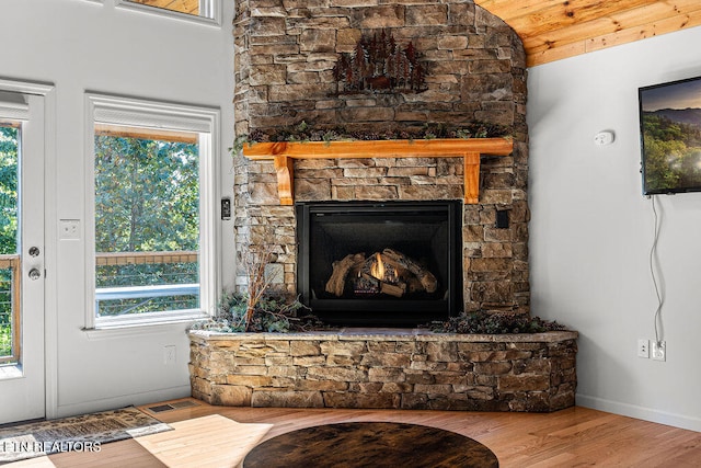 interior space featuring a stone fireplace, wood ceiling, vaulted ceiling, and hardwood / wood-style flooring