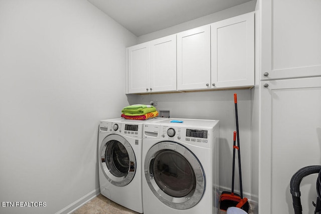 washroom featuring separate washer and dryer, light tile patterned flooring, and cabinets