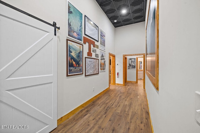 hallway featuring a barn door and hardwood / wood-style floors