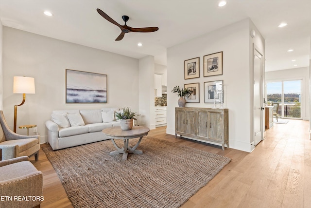 living room with light hardwood / wood-style floors and ceiling fan