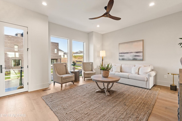 living room featuring light hardwood / wood-style floors and ceiling fan