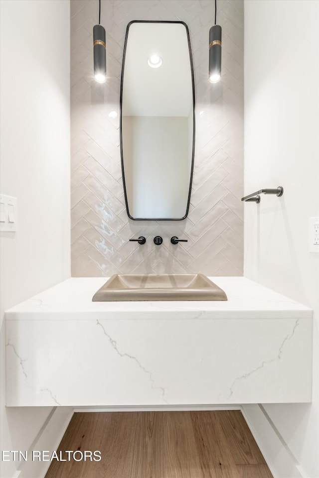 bathroom featuring decorative backsplash and hardwood / wood-style flooring