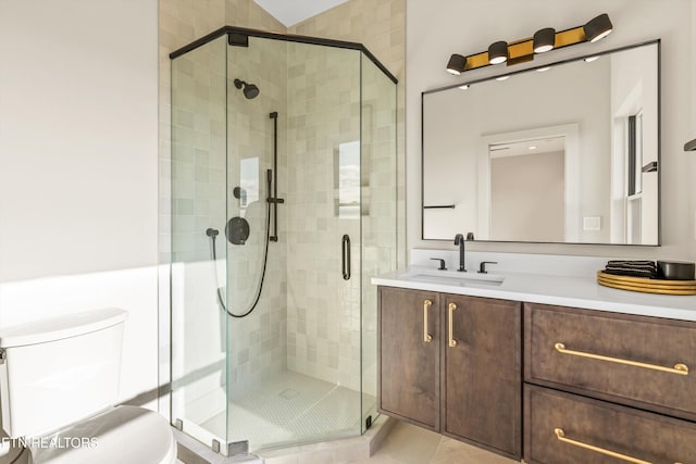 bathroom featuring tile patterned flooring, vanity, toilet, and a shower with shower door