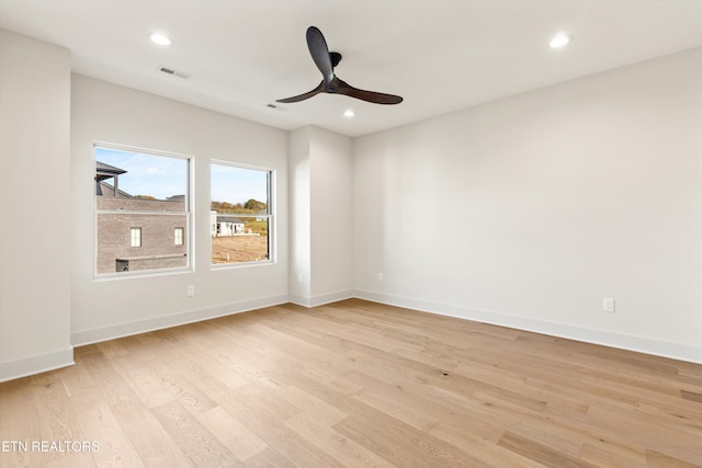 empty room with ceiling fan and light hardwood / wood-style flooring