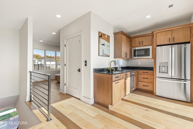 kitchen featuring light wood-type flooring, sink, and stainless steel appliances