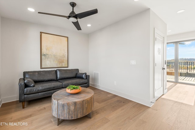 living room with light hardwood / wood-style floors and ceiling fan