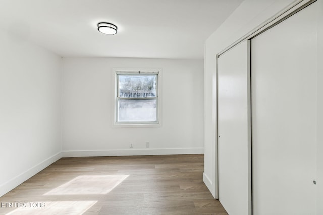 unfurnished bedroom with a closet and light hardwood / wood-style flooring