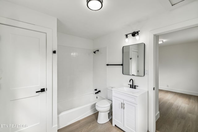 full bathroom featuring vanity, hardwood / wood-style floors, tiled shower / bath combo, and toilet