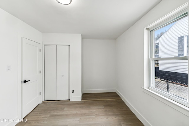 unfurnished bedroom with light hardwood / wood-style floors and a closet