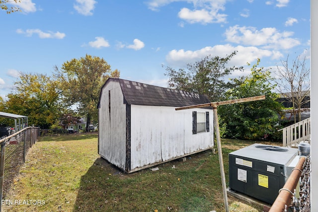 view of outdoor structure with a yard and central air condition unit