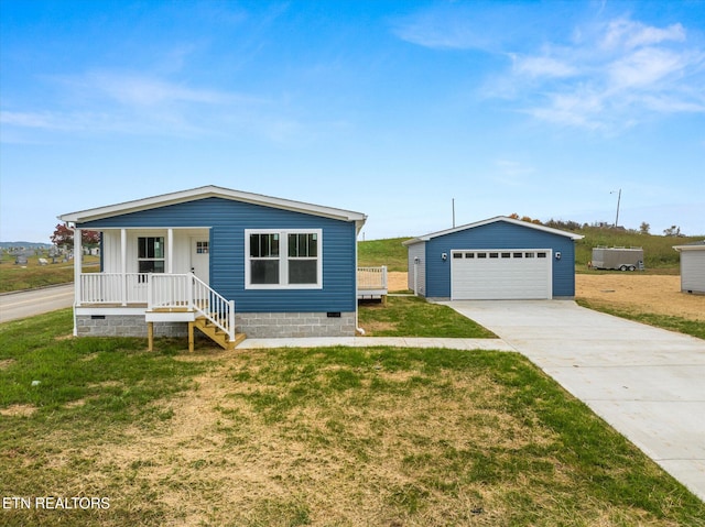 view of front of home featuring covered porch, a front lawn, an outbuilding, and a garage