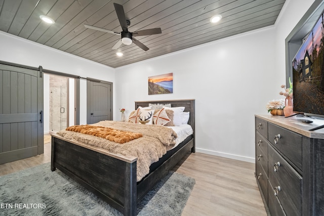 bedroom featuring crown molding, a barn door, wooden ceiling, ceiling fan, and light hardwood / wood-style flooring