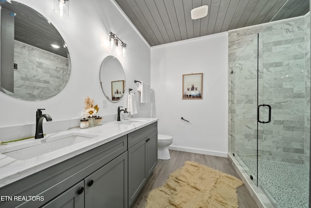 bathroom with wood-type flooring, toilet, vanity, crown molding, and a shower with shower door