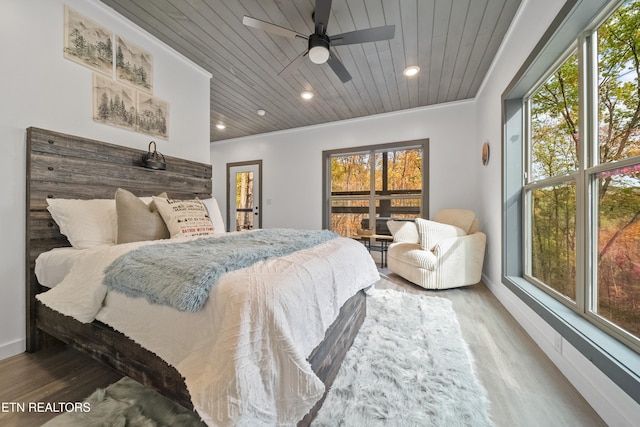 bedroom with dark wood-type flooring, wooden ceiling, ceiling fan, and multiple windows