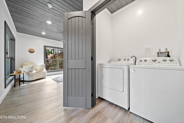 laundry area featuring ornamental molding, light hardwood / wood-style flooring, washing machine and dryer, and wooden ceiling