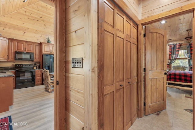 hall featuring high vaulted ceiling, light hardwood / wood-style floors, wooden walls, and wooden ceiling