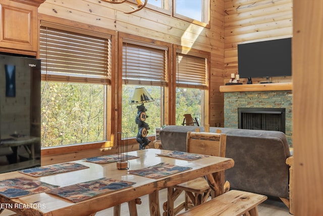 dining space featuring a fireplace and wooden walls