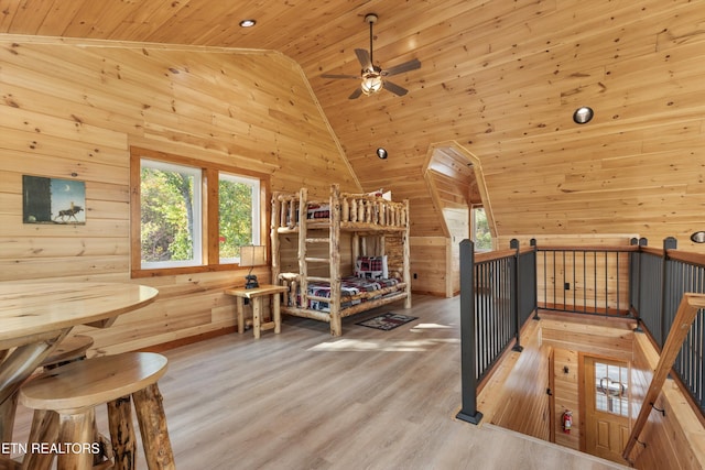 interior space with high vaulted ceiling, light hardwood / wood-style flooring, wood walls, and wood ceiling