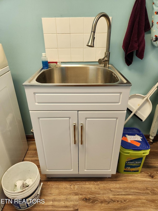 interior space with white cabinets, hardwood / wood-style flooring, and sink