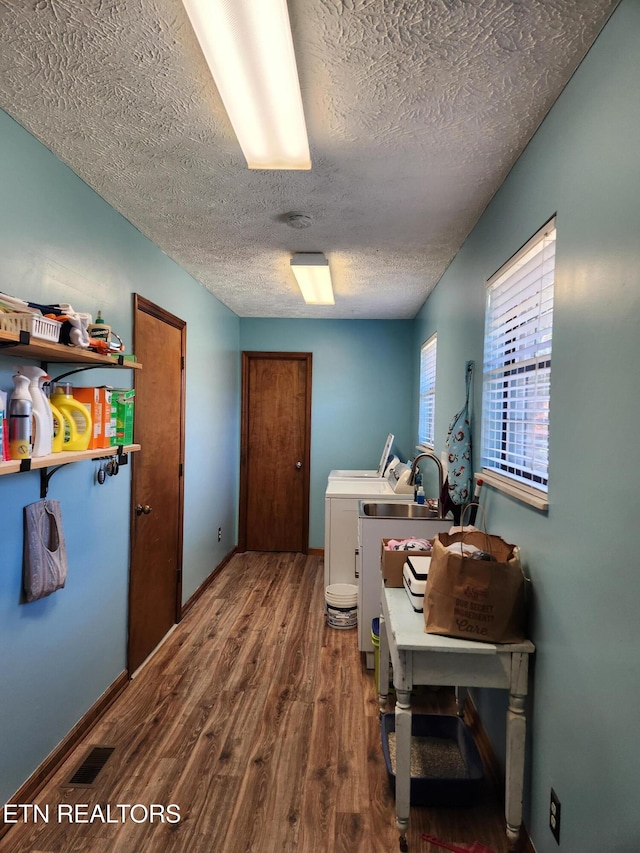 washroom featuring hardwood / wood-style floors, independent washer and dryer, and a textured ceiling