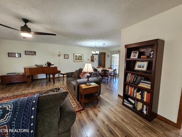 living room with wood-type flooring, a textured ceiling, and ceiling fan with notable chandelier