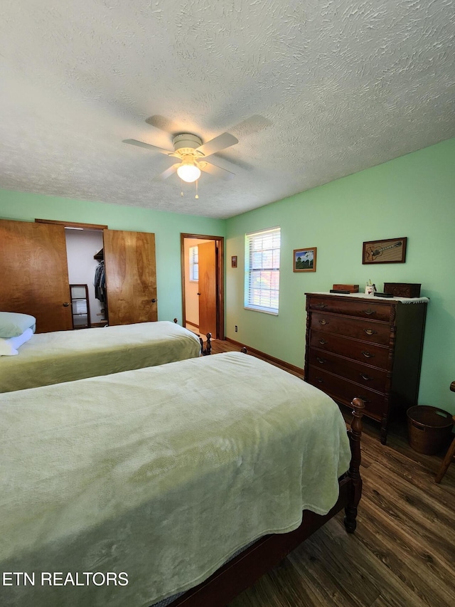 bedroom featuring a textured ceiling, dark wood-type flooring, and ceiling fan