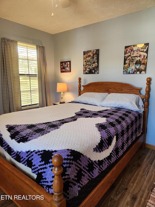 bedroom featuring a textured ceiling and dark hardwood / wood-style floors