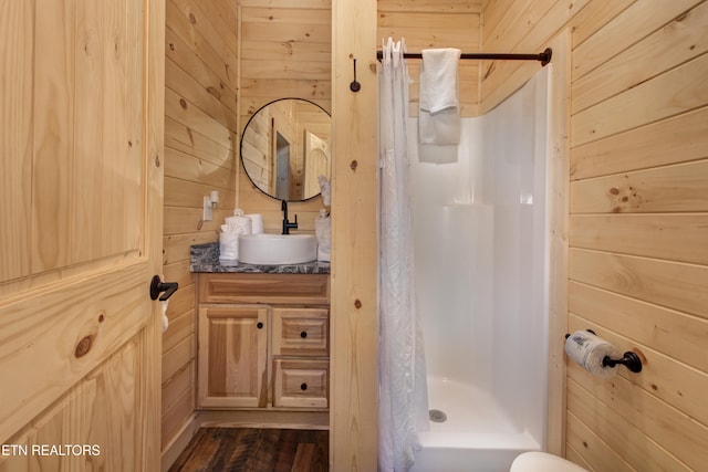 bathroom with vanity, curtained shower, and wooden walls