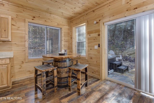 dining area with dark hardwood / wood-style flooring, plenty of natural light, wooden walls, and wood ceiling