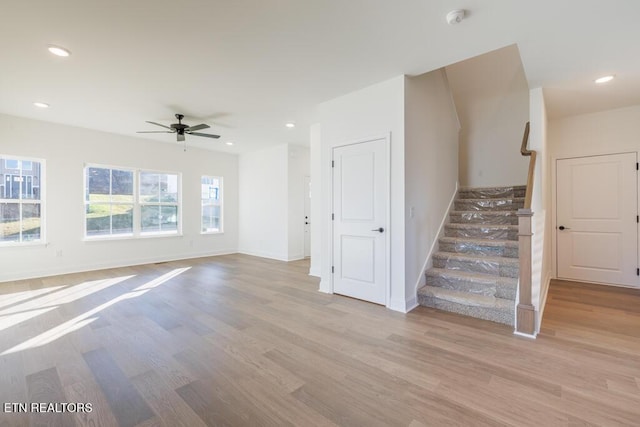 unfurnished living room featuring ceiling fan and light wood-type flooring