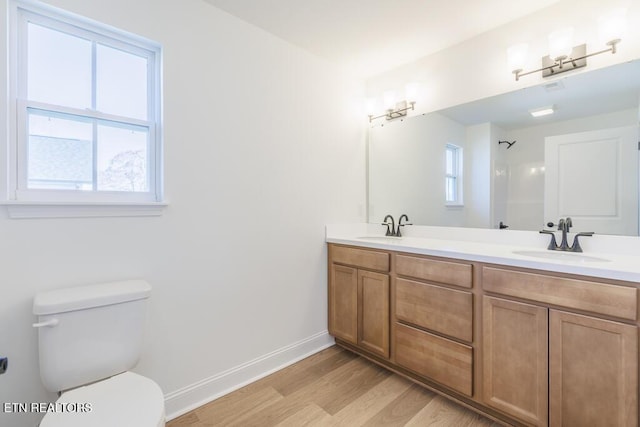 bathroom with vanity, toilet, wood-type flooring, and a shower