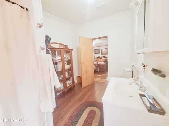 bathroom with hardwood / wood-style floors, vanity, and ornamental molding