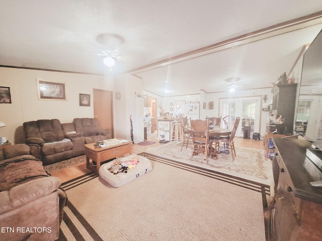 living room featuring hardwood / wood-style flooring, ceiling fan, and crown molding