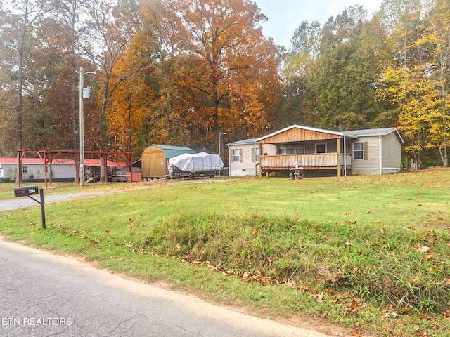 view of front of home with a front lawn and a storage shed