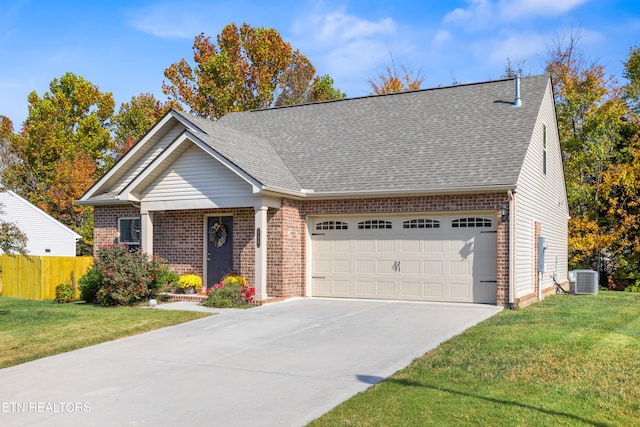 view of front of home featuring a front yard, a garage, and central AC unit