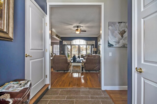 foyer with ornamental molding, dark hardwood / wood-style floors, and ceiling fan