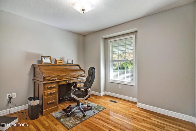 home office with hardwood / wood-style flooring and a textured ceiling