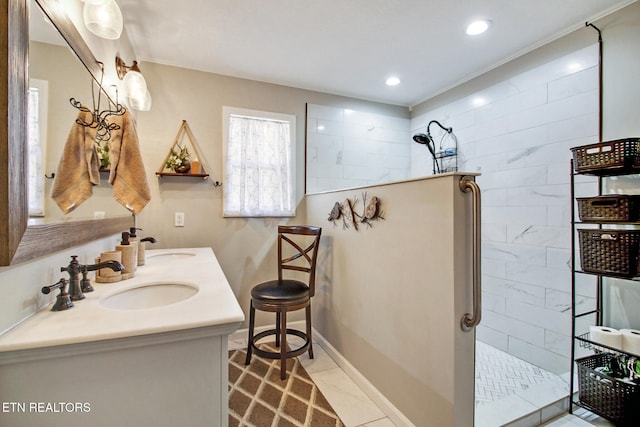 bathroom featuring vanity, tiled shower, and tile patterned flooring