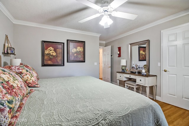 bedroom with ceiling fan, hardwood / wood-style flooring, ornamental molding, and a textured ceiling