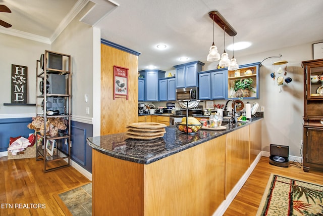 kitchen with kitchen peninsula, ornamental molding, light hardwood / wood-style floors, decorative light fixtures, and blue cabinets