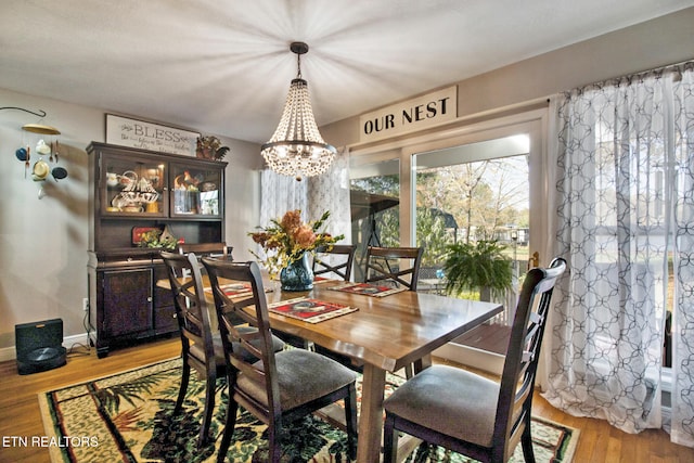 dining area with a notable chandelier and light wood-type flooring