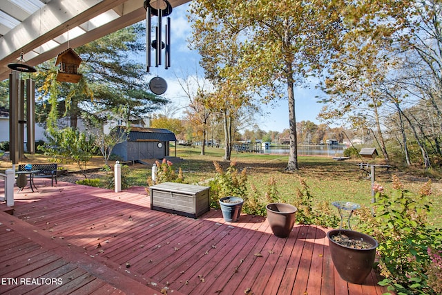 wooden terrace with a storage unit and a water view