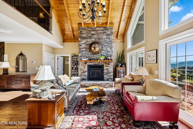 living room with wood ceiling, high vaulted ceiling, wood-type flooring, and a stone fireplace