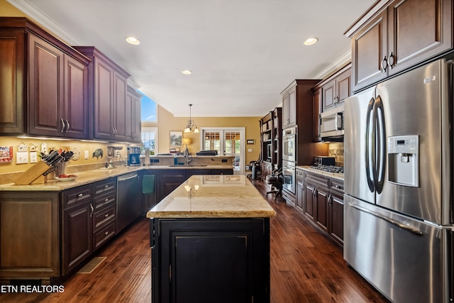 kitchen with kitchen peninsula, stainless steel appliances, sink, pendant lighting, and dark hardwood / wood-style flooring