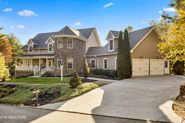 view of front of property with a porch, a front lawn, and a garage